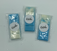 Load image into Gallery viewer, The picture is of a wax melt in the shape of a chocolate bar. The colour is blue and white wrapped in plastic with the brand name "Kotcha" on it. There are crystals surrounding the image and a white background.