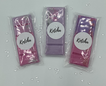 Load image into Gallery viewer, The picture is of a wax melt in the shape of a chocolate bar. The colour is purple with silver biodegradable glitter wrapped in plastic with the brand name &quot;Kotcha&quot; on it. There are crystals surrounding the image and a white background.
