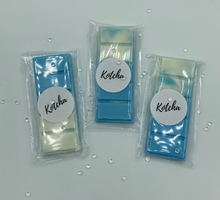 Load image into Gallery viewer, The picture is of a wax melt in the shape of a chocolate bar. The colour is blue and white wrapped in plastic with the brand name &quot;Kotcha&quot; on it. There are crystals surrounding the image and a white background.
